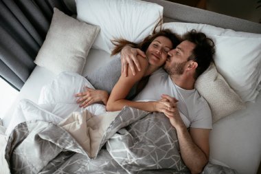 Yatakta genç bir çift. Mutlu çift yatakta dinleniyor..