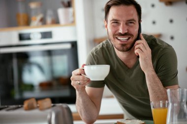 Adam mutfakta kahvaltı yapıyor.