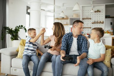  Mutlu çift evde çocuklarla video oyunu oynuyor..