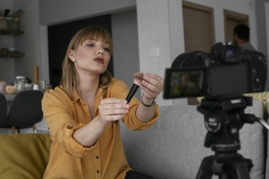 Kadın video kaydedicisi, kanalı için makyaj dersi kaydediyor. Sosyal medyada paylaşmak için makyaj dersi alan genç ve güzel bir kadın..