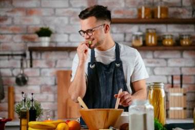 Mutfakta makarna hazırlayan yakışıklı adam. Lezzetli yemek pişiren adam..