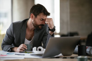 Yorgun iş adamı proje üzerinde çalışıyor. Ofiste çalışan genç bir işadamı..