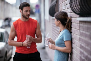 Atletik çift şehirde koştuktan sonra dinleniyor. Mutlu çift sabahları eğleniyor...