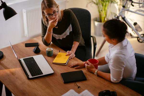 Две деловые женщины обсуждают работу в офисе