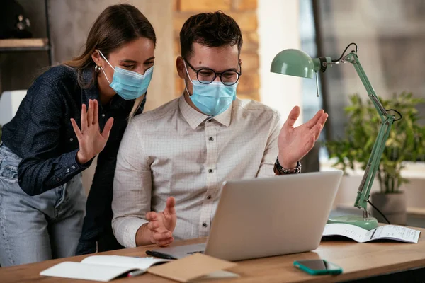 Businessman and businesswoman with medical mask in office. Colleagues working together. Covid19 concept