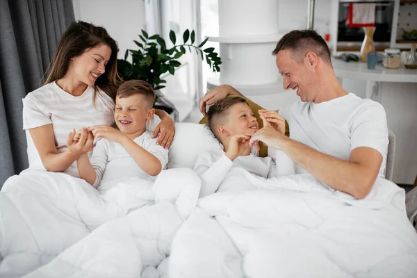 가족들은 침대에서 즐겁게 지낸다 아들들 침대에서 부모들 — 스톡 사진