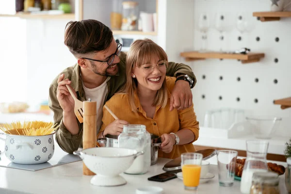 Karı koca mutfakta. Genç çift evde lezzetli yemekler hazırlıyor..