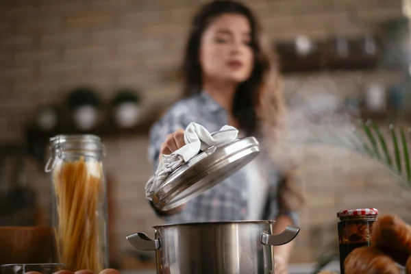 Young Woman Cooking in the kitchen. Woman cooking pasta dish.