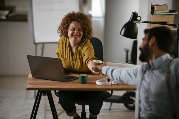 Business people in office. Businesswoman and businessman discussing work while drinking coffee.