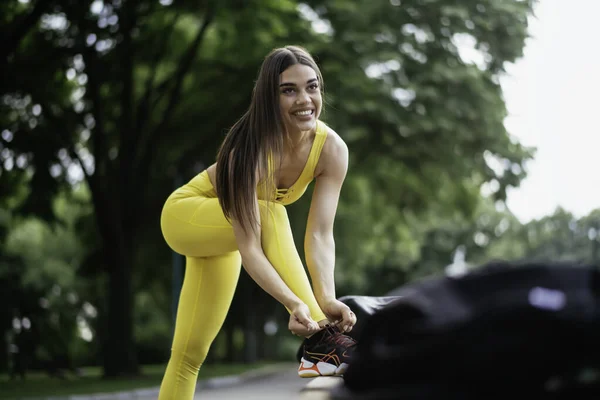 漂亮的女人在跑道上摆姿势 穿着黄色运动服的年轻女子 — 图库照片
