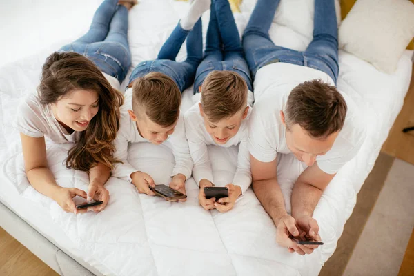 Família Usando Telefones Celulares Pais Filhos Usando Telefones Inteligentes Casa — Fotografia de Stock