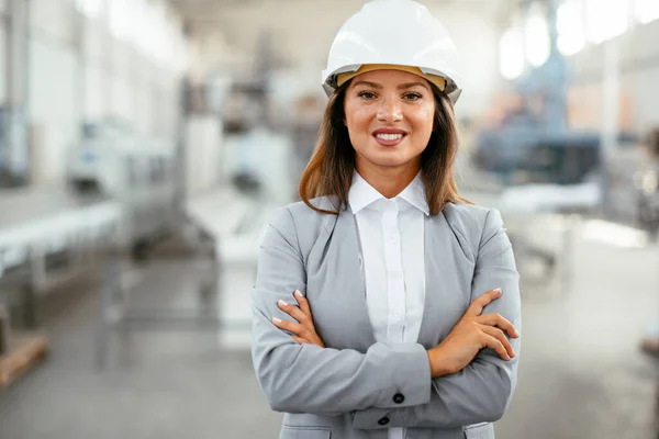 Portrait of an industrial woman engineer standing in a factory.