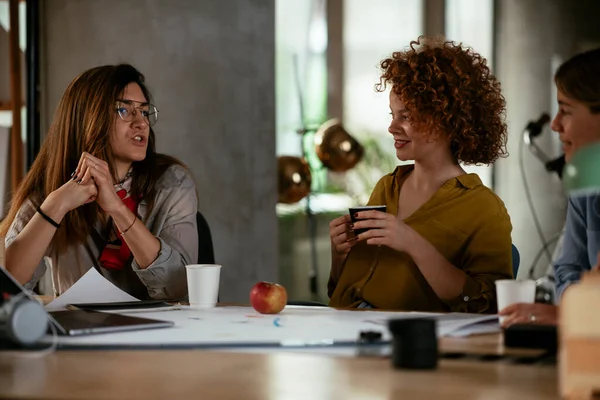 Businesswomen working on a new project. Colleagues discussing work in office.