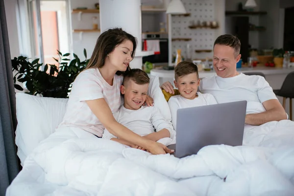 아름다운 부모와 아이들 집에서 즐기고 있습니다 노트북으로 영화를 — 스톡 사진