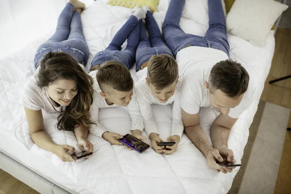 Família Usando Telefones Celulares Pais Filhos Usando Telefones Inteligentes Casa — Fotografia de Stock