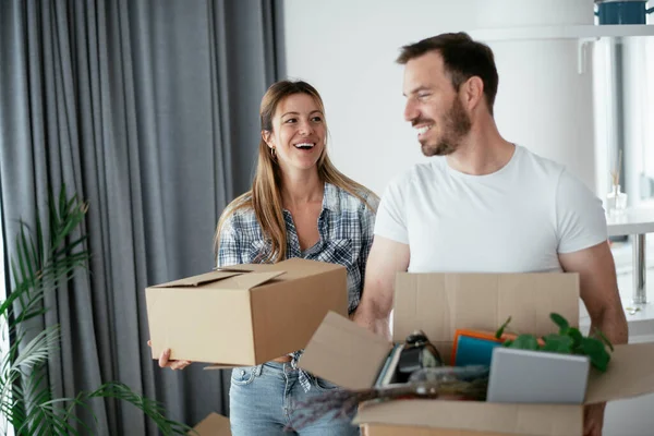 Boyfriend and girlfriend are moving in a apartment. Young couple are unpacking their belongings.