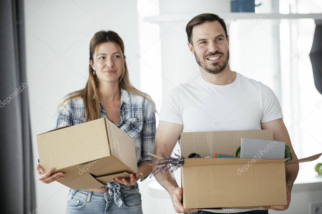 Boyfriend and girlfriend are moving in a apartment. Boyfriend and girlfriend are unpacking their belongings.