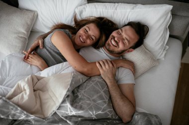 Yatakta genç bir çift. Mutlu çift yatakta dinleniyor..