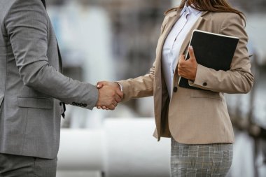 Mutlu iş adamı ve iş kadını el sıkışması fabrikada