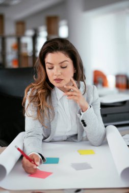 Ofiste proje üzerinde çalışan güzel bir genç kadın.