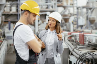 Fabrika işçisi ve mühendis teftiş yapıyor. Fabrika işçisi ve işkadını üretim hattında..