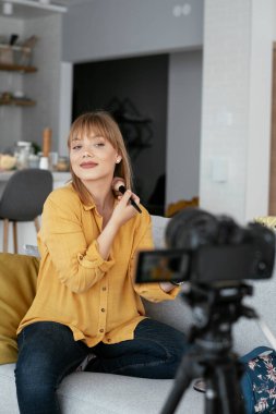 Kadın video kaydedicisi, kanalı için makyaj dersi kaydediyor. Sosyal medyada paylaşmak için makyaj dersi alan genç ve güzel bir kadın..