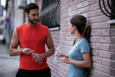 Atletik çift şehirde koştuktan sonra dinleniyor. Mutlu çift sabahları eğleniyor...