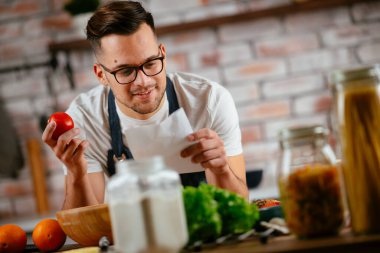 Mutfakta makarna hazırlayan yakışıklı adam. Lezzetli yemek pişiren adam..