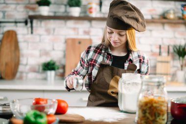 Küçük kız mutfakta eğleniyor. Mutfakta oynayan tatlı kız..