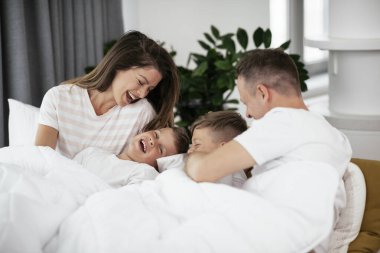 Çocuklu güzel ebeveynler evde eğleniyorlar.