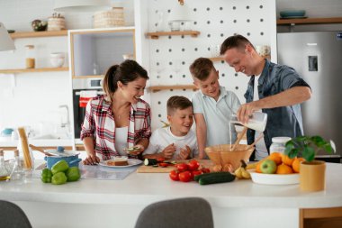Evde genç ve mutlu bir aile yemeği. Annem ve babam oğullarımla kahvaltı hazırlıyorlar..