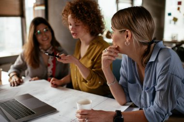 İş kadınları yeni bir proje üzerinde çalışıyor. İş arkadaşları ofiste iş tartışıyor.