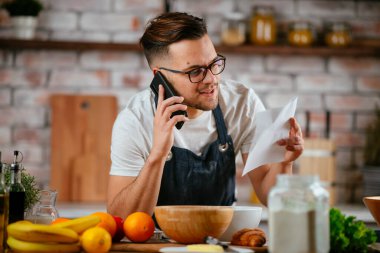 Mutfakta makarna hazırlayan yakışıklı adam. Lezzetli yemek pişiren adam..