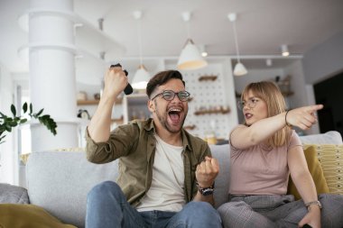 Karı koca oturma odasında joysticklerle oyun oynuyorlar. Sevgili çift evde video oyunu oynuyor..