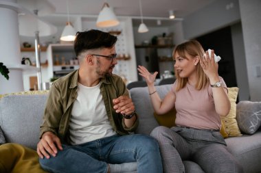 Erkek arkadaşı ve kız arkadaşı kanepede tartışıyor. Kızgın kadın erkek arkadaşına bağırıyor..