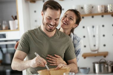 Genç çift evde krep yapıyor. Sevgili çift yemek yaparken eğleniyor..