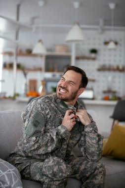 Kanepede oturan bunalımlı asker. Genç denizci travma sonrası stres bozukluğu yaşıyor..