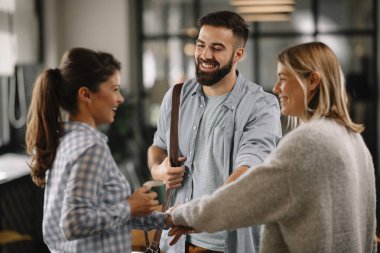 Modern açık uzay ofisinde sıradan iş adamlarından oluşan bir grup. İş kadınları ve işadamları yeni proje hakkında konuşuyor.