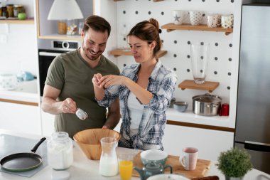 Genç çift evde krep yapıyor. Sevgili çift yemek yaparken eğleniyor..