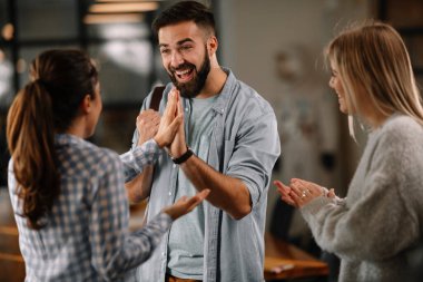 Modern açık uzay ofisinde sıradan iş adamlarından oluşan bir grup. İş kadınları ve işadamları yeni proje hakkında konuşuyor.