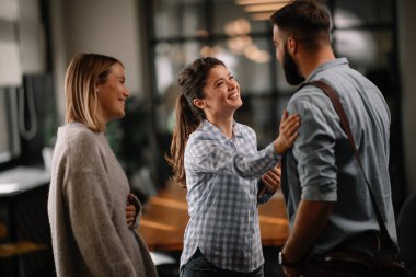 Modern açık uzay ofisinde sıradan iş adamlarından oluşan bir grup. İş kadınları ve işadamları yeni proje hakkında konuşuyor.