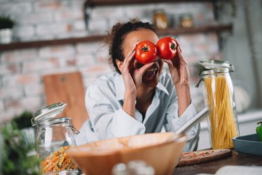 Güzel bir kadın yemek pişiriyor ve mutfakta eğleniyor. Kız mutfakta sağlıklı yemek pişiriyor..
