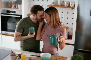 Mutlu çift mutfakta kahvaltı yapıyor. 