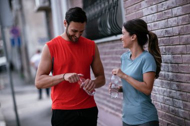 Atletik çift şehirde koştuktan sonra dinleniyor. Mutlu çift sabahları eğleniyor...