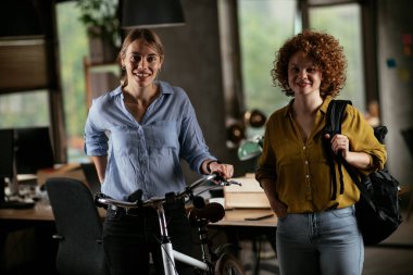 Mutlu genç kadınlar ofiste kalır ve gülümserler.