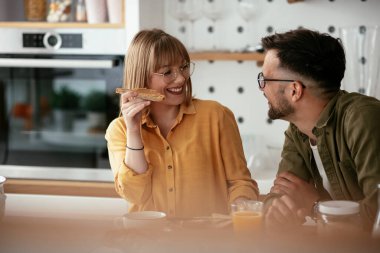 Genç çift evde lezzetli yemekler yapıyor. Sevgi dolu çift mutfakta eğleniyor..