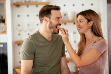 Genç çift evde sandviç yapıyor. Sevgi dolu çift mutfakta eğleniyor..