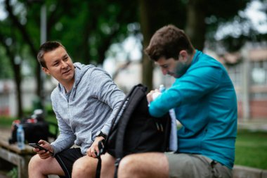 Koşmaktan istirahat eden zinde genç adamlar. Dışarıda antrenman yapan iki arkadaş..