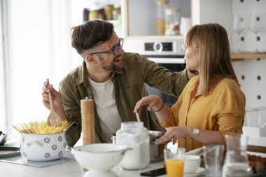 Karı koca mutfakta. Genç çift evde lezzetli yemekler hazırlıyor..