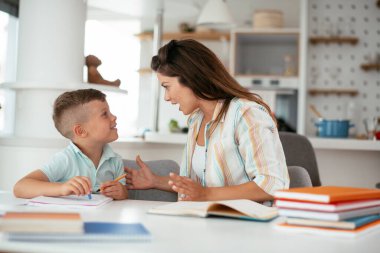 Anne oğluyla ödev yapıyor.